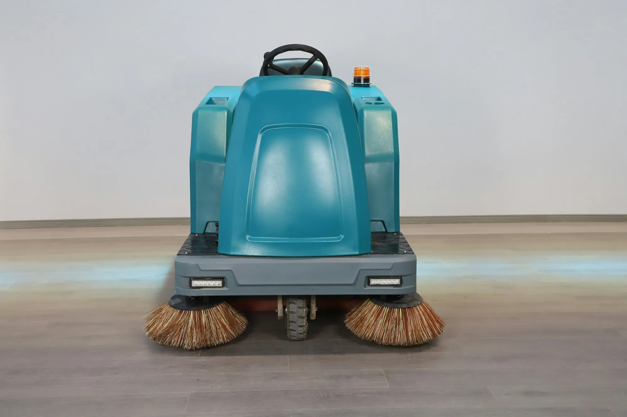 Front view of a commercial floor sweeper's brushes